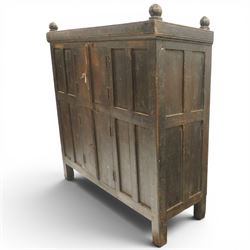 19th century oak hutch cupboard, plank top with moulded cornice and turned finials, panelled front enclosed by two tiers of central double doors with iron hinges and wooden latches, flanked by fixed fielded panels, on stile supports