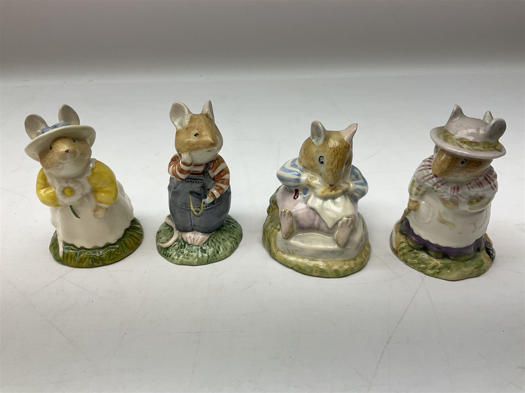 Fifteen Royal Doulton Brambly Hedge figures, comprising Wilfred Toadflax, Dusty Dogwood, Mrs Toadflax, Mr Apple, Primrose Woodmouse, Lord Woodmouse, Poppy Everbright, two Lady Woodmouse, two Old Mrs Everbright, Mr Toadflax, Mrs Apple, Santa Bunnykins and Bunnykins, together with three Royal Albert Wind in the Willows figures comprising Ratty, Badger and Mole, all with printed marks beneath (18)
