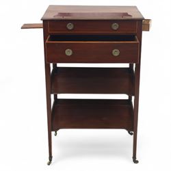 George III mahogany and boxwood-strung drawing table, the rectangular sloping reading surface with rest and oak stay, above a blind drawer and a drawer fitted with brass ring handles, side with pull-out candleholder and inkwell compartment, raised on square-section tapered legs with brass box castors united by two galleried under tiers