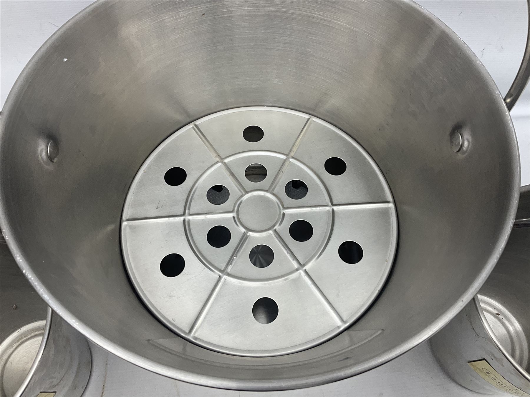 Stainless steel Laurent-Perrier champagne bucket, with engraved brass plaque and grip to swing handle, together with two matching smaller, largest D38cm (3)