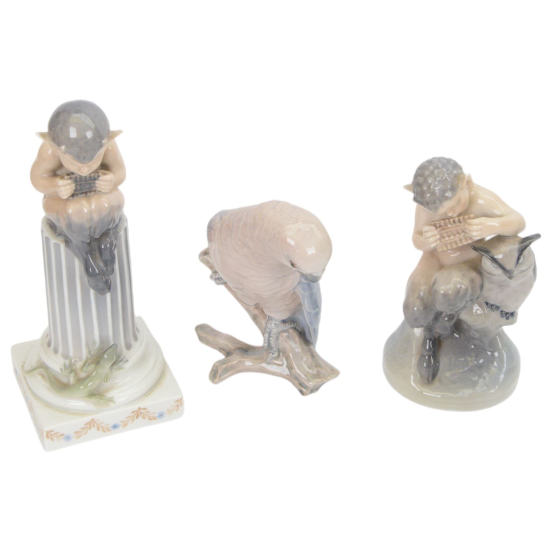 Two Royal Copenhagen figurines of fawns, comprising a fawn with an owl, no 2107 and fawn on plinth no 433, together with Bing & Grondahl, figure of a parrot on branch