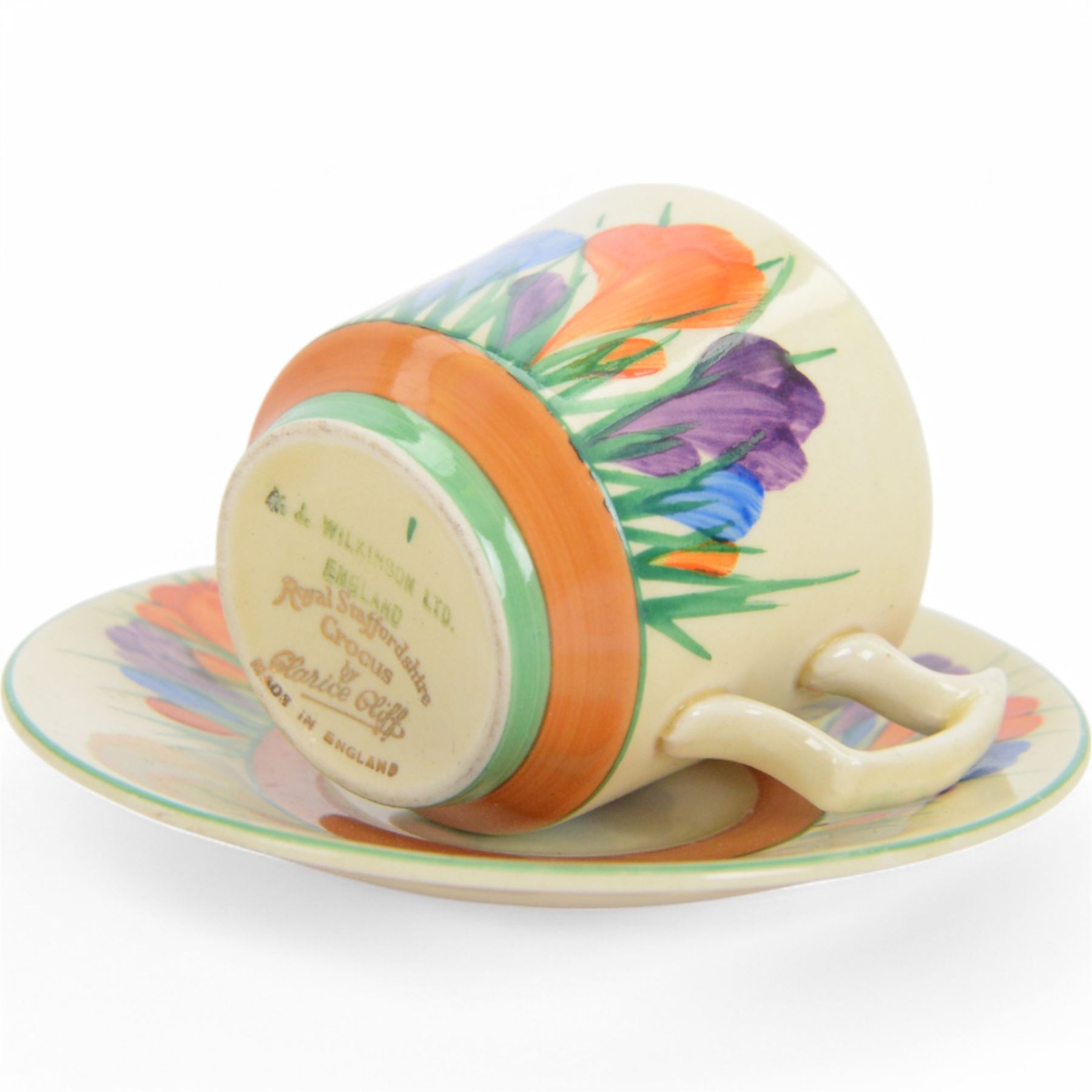 Royal Staffordshire Crocus by Clarice Cliff teacup and saucer, with printed mark beneath, together with a Clarice Cliff Crocus pattern flower frog, with printed mark beneath, cup H6cm