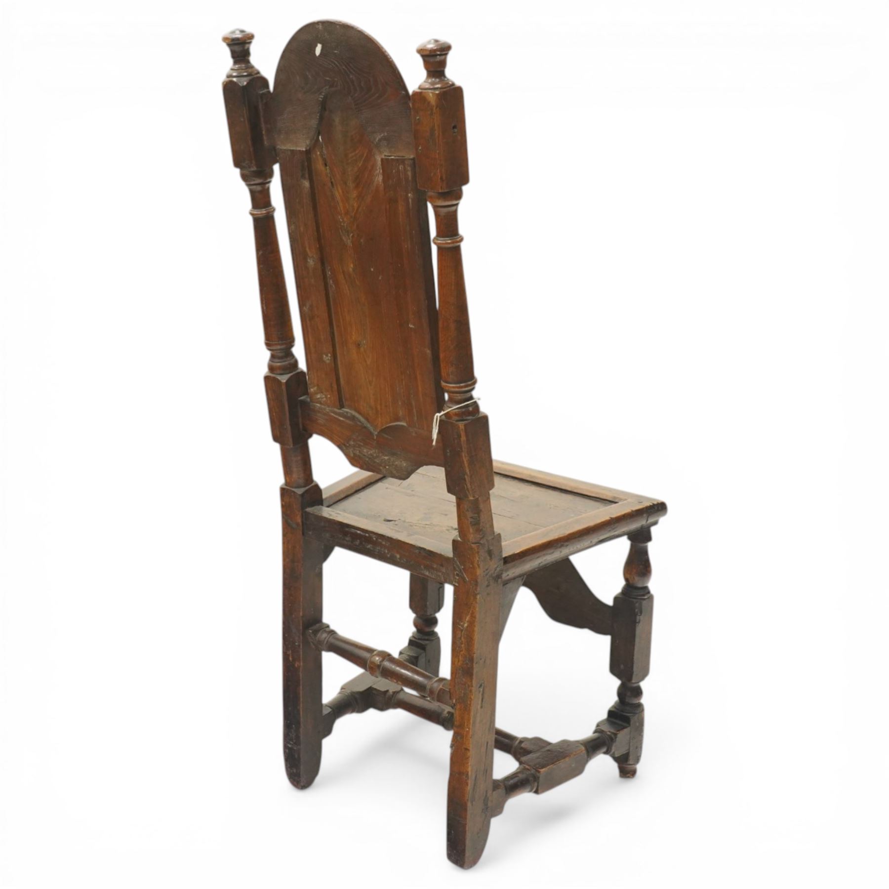17th century oak and elm hall chair, the high-back with shield-shaped fielded panelling flanked by turned uprights, over a panelled seat, raised on turned supports united by H-stretcher with moulded serpentine front-stretcher