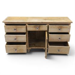 Victorian waxed pine farmhouse dresser, featuring seven drawers with central cupboard, moulded glass handles, raised on turned feet