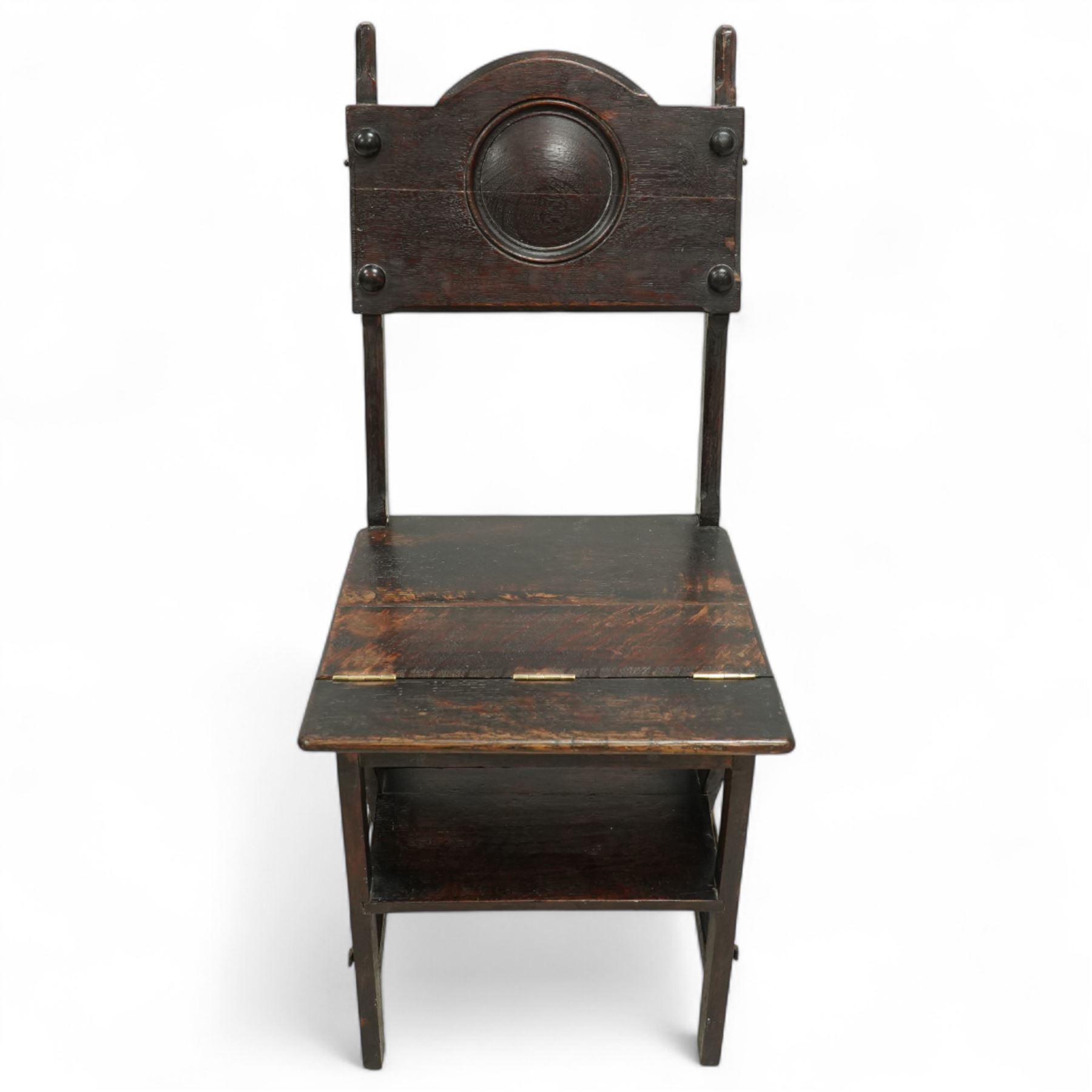 Arts & Crafts oak metamorphic chair, circular panelled back above hinged seat opening into a set of library steps with brass securing straps, circa 1900