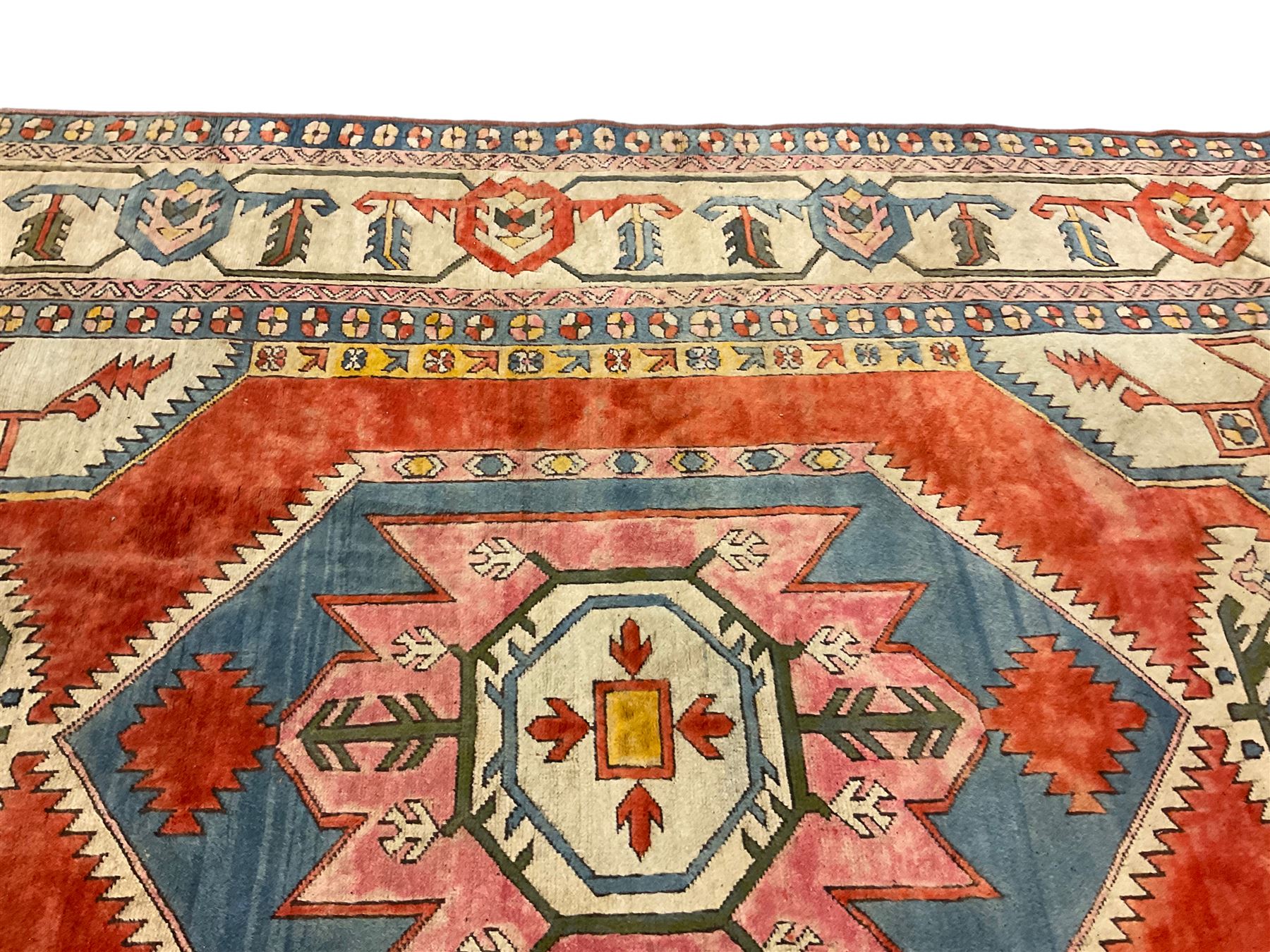 Anatolian Turkish ivory ground carpet, the central geometric pole medallion within an amber field, the guarded border decorated with stylised plant motifs surrounded by bands of repeating flower heads