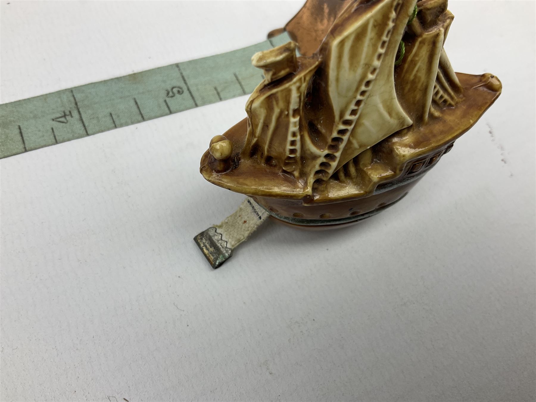 Copper tape measure in the form of a ship`s wheel, marked 'Rd. 128885' to the front, and a celluloid tape measure in the form of a galleon, wheel H4cm