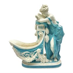 Rare 19th century Minton turquoise glaze majolica 'The Reader' flower holder, after Albert Carrier-Belleuse, modeled as a maiden in classical drapery reading whilst leaning against the pillar back of the helmet shaped cistern detailed with a caryatid and floral swags, the whole upon an oval plinth with Greek key border, with impressed marks beneath, H44cm