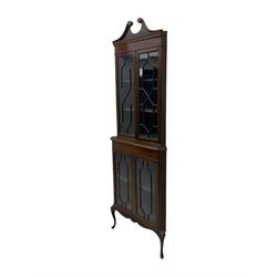 Edwardian mahogany corner display cabinet, scrolled swan neck pediment over astragal glazed doors, fabric lined interior, on cabriole feet 