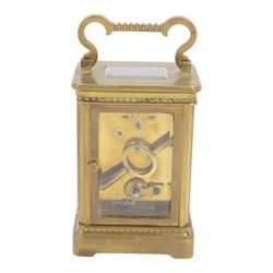 French-Edwardian 8-day timepiece carriage clock with a cylinder platform escapement, anglaise style brass case with four glass panels, dial with a polished gilt mask and foliate decoration, white enamel chapter with Arabic numerals and steel spade hands, . With Key. 