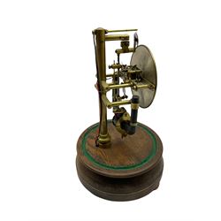 A 1920’s French 800-day Bulle electric battery clock on a turned wooden base, with a circular silvered dial with Arabic numerals, minute track and steel spade hands, skeletonised brass movement and escapement, the magnetic pendulum action is activated by the battery power source located in the base of the clock. No Dome.