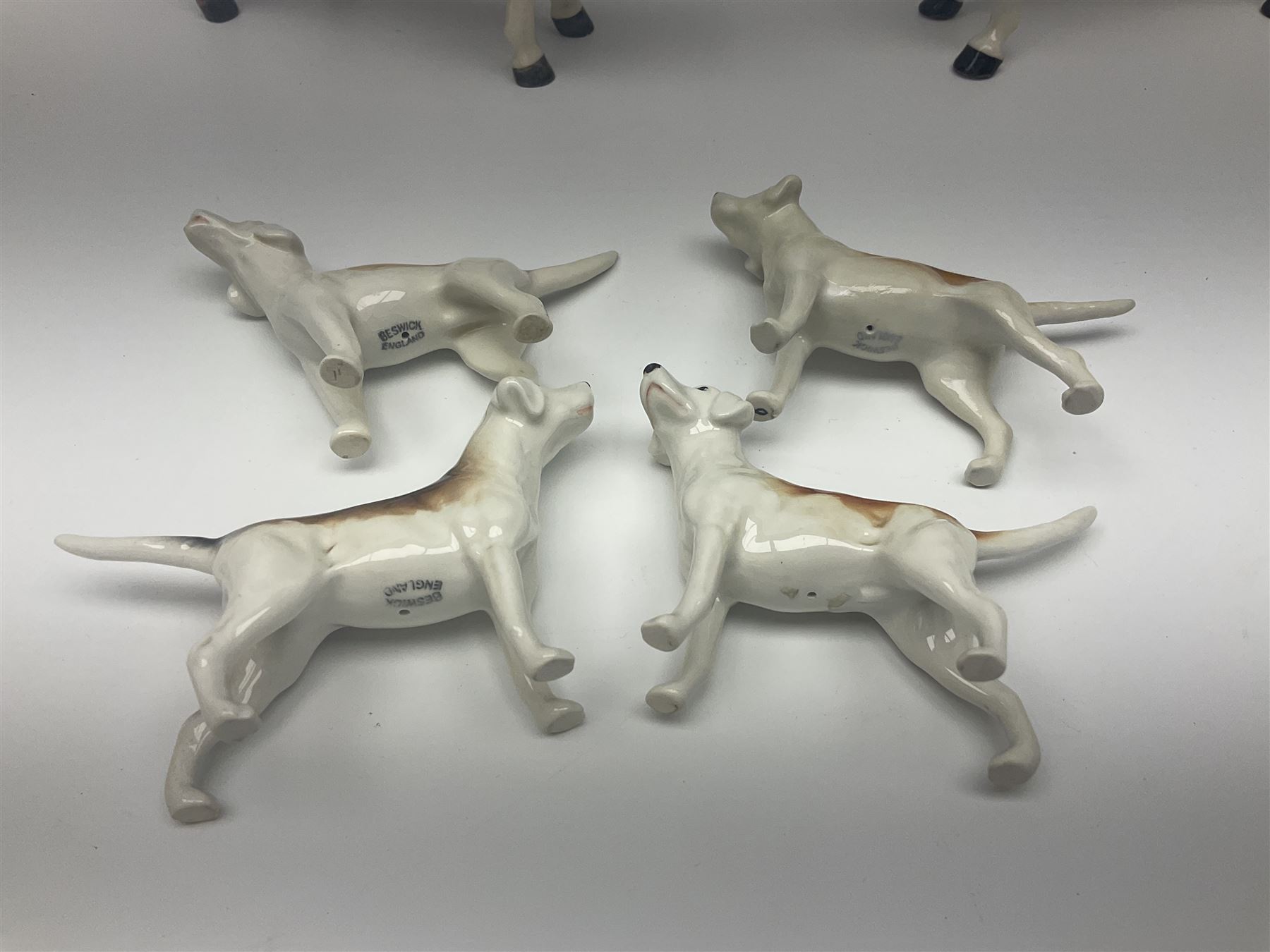 Beswick hunting group, comprising huntswoman on grey horse no 1730, huntsman on brown horse no 1501, fox figure no 1440 and eight fox hounds, all with printed marks beneath (11)