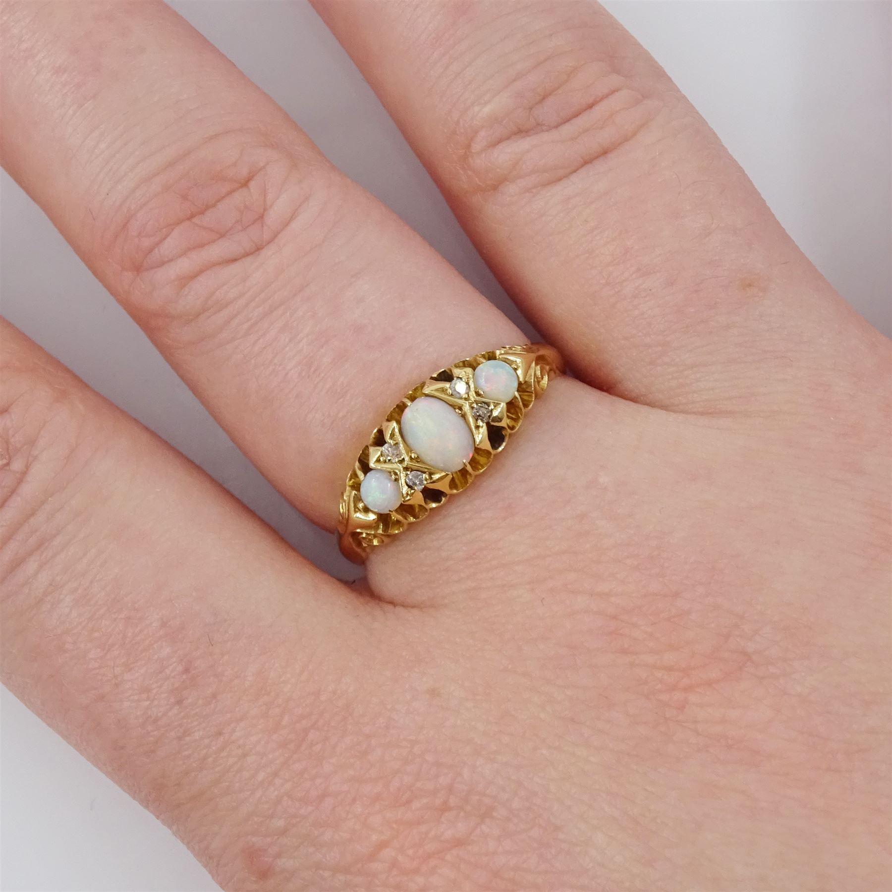 Edwardian 18ct gold opal and diamond ring, three cabochon cut opals, the principal stone with two round cut diamonds set either side, Birmingham 1910