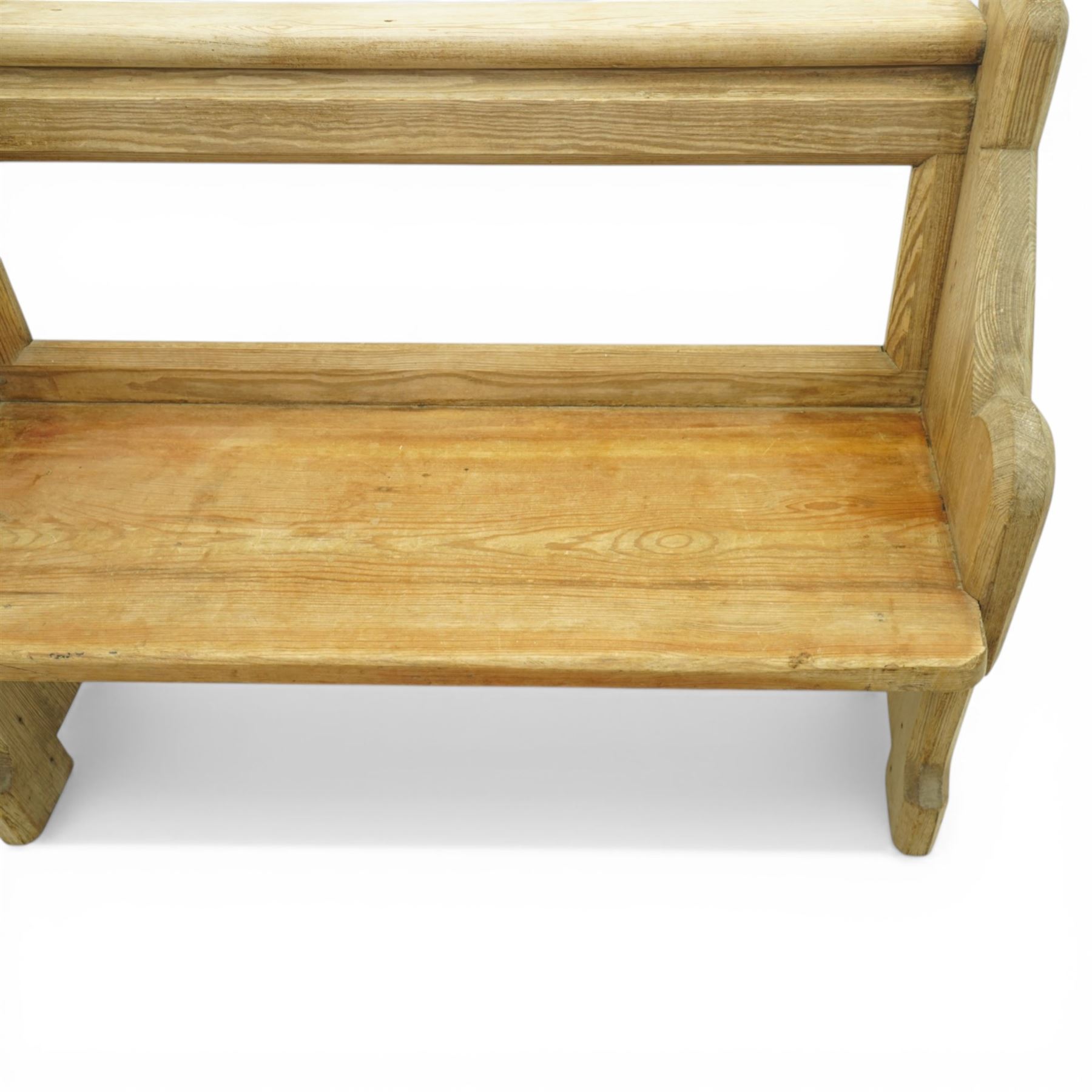 19th century pine pew of small proportions, open rectangular back with panelled frame, rounded top rail and plank seat, shaped slab ends with chamfered detail