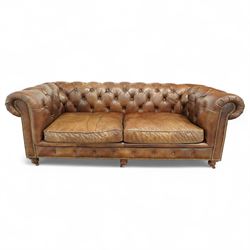 Timothy Oulton, Halo - Late 20th century brown leather Chesterfield settee, the upholstered frame with deep buttoning to back and arms, large scroll terminals with brass studwork, twin seat cushions, raised on castored legs