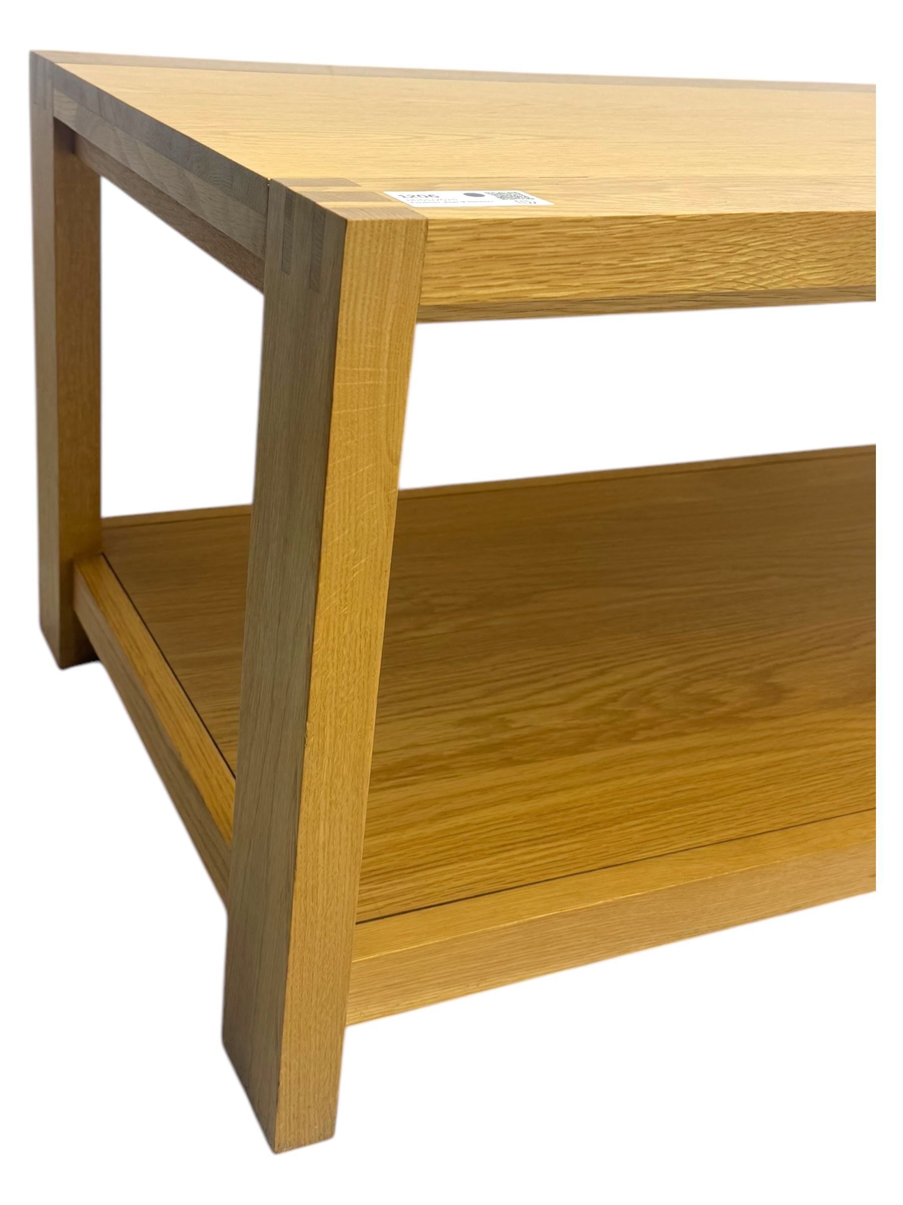 Light oak rectangular coffee table, with exposed finger joints to the corners, raised above a full-length undertier on straight supports