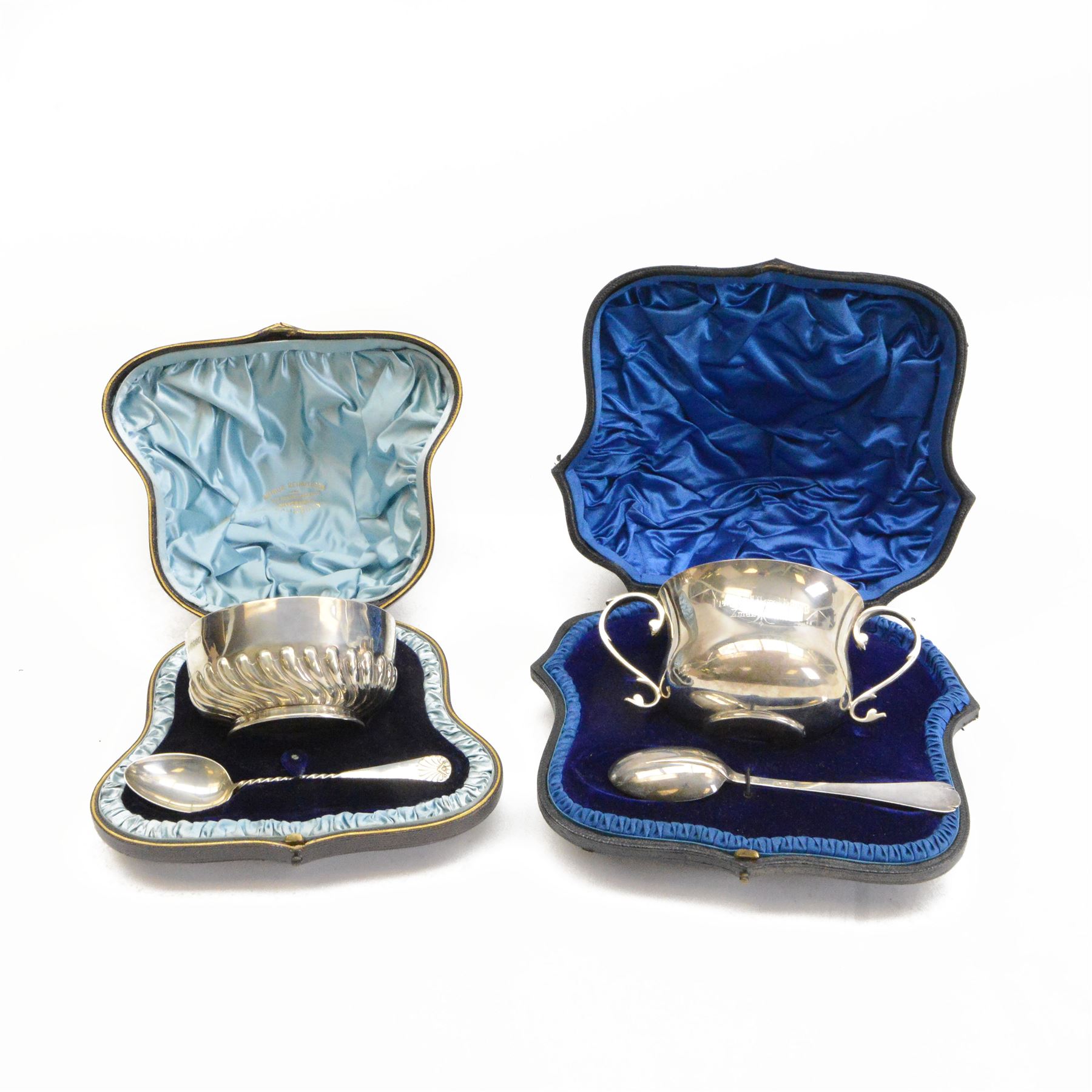 Two Victorian silver Christening sets, the first a twin handled porringer with presentation engraving to body and a matching spoon with rattail bowl, hallmarked Wakely & Wheeler, London 1898, the second example with circular part fluted bowl and matching spoon with twist handle and palmette finial, hallmarked Martin, Hall & Co, London 1884, both contained within tooled leather cases with fitted blue velvet and silk interior