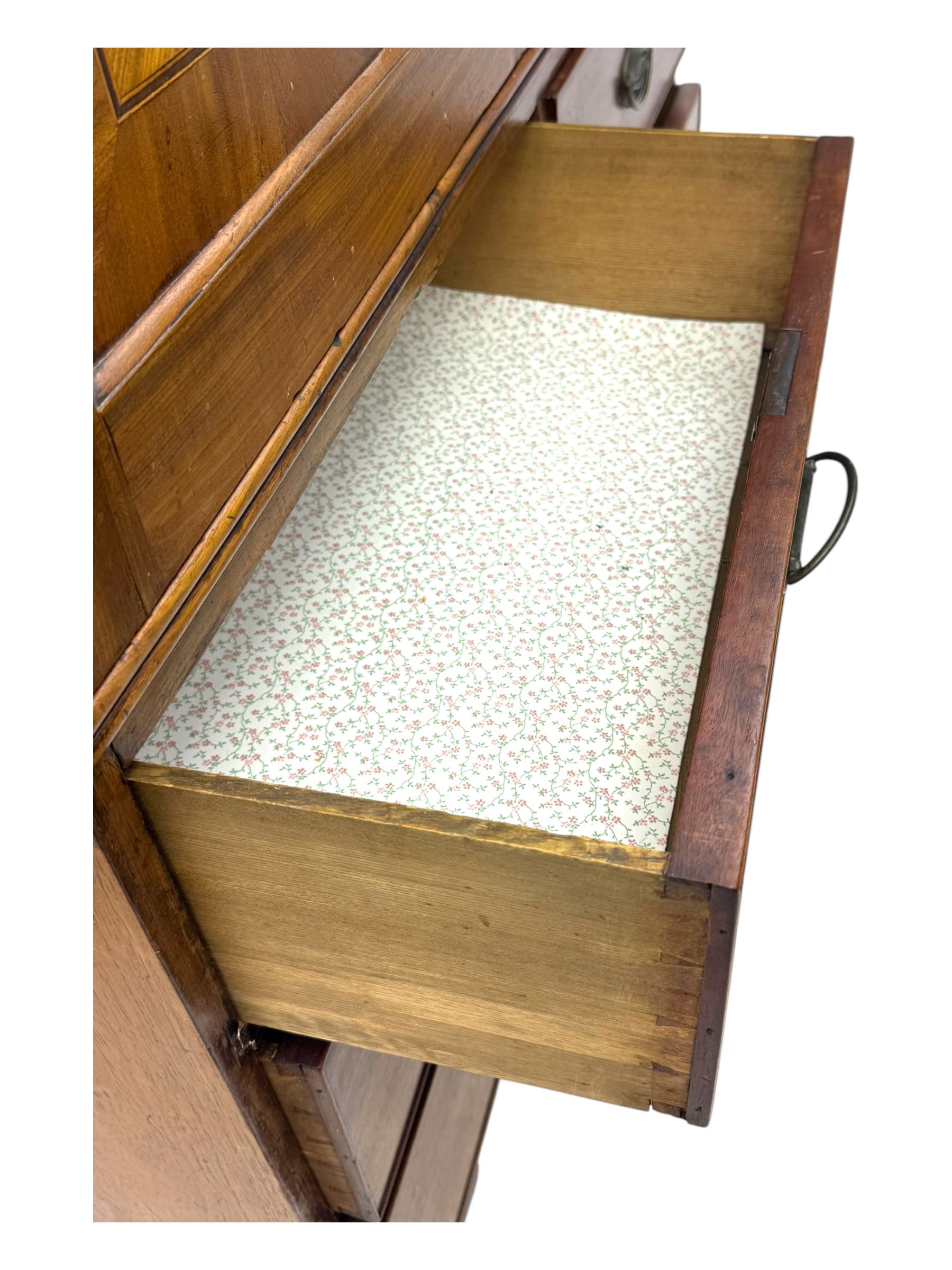 Early 19th century mahogany linen press cupboard, projecting moulded cornice over figured frieze, two panelled doors enclosing shelves, fitted with two short and two long cock-beaded drawers, on bracket feet 