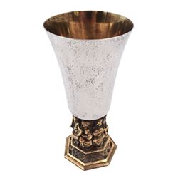 Modern limited edition silver goblet, commemorating the seventh centenary of the completion of Lincoln Cathedral, designed by Hector Miller for Aurum, the tapering cylindrical bowl with planished decoration and gilt interior, upon an ornate parcel gilt stem, depicting figures from the Angel Choir of Lincoln Cathedral, upon a heptagonal foot with pierced quatrefoil decoration, no. 112/700,  hallmarked Hector Miller, London 1981, H16.5cm
