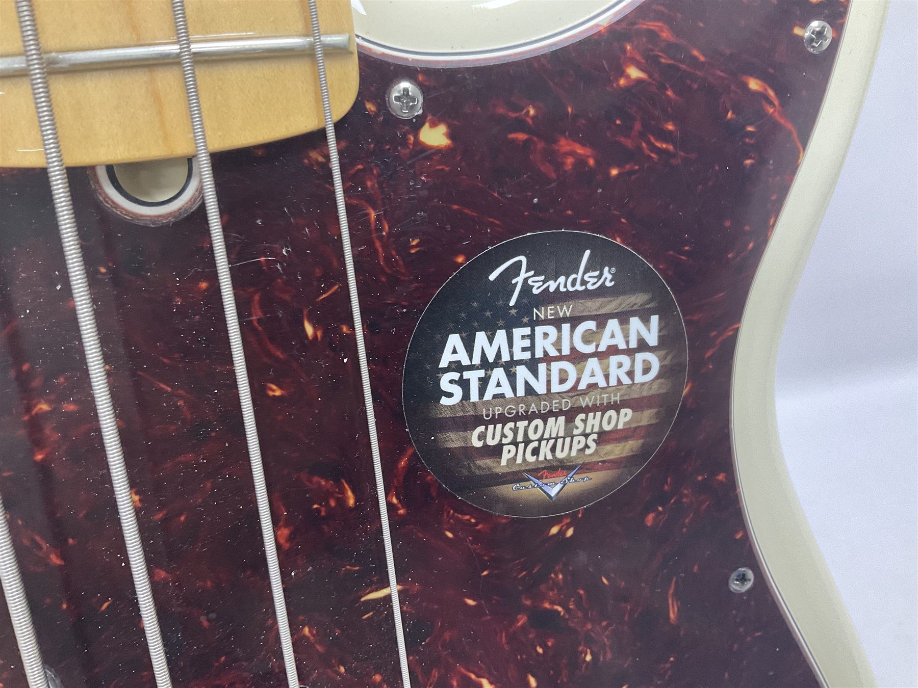 Fender Precision Bass guitar, in Olympic White finish with tortoiseshell effect scratchboard, serial no US15103092, in black Fender hard case with Fender strap and warranty card, guitar L116cm