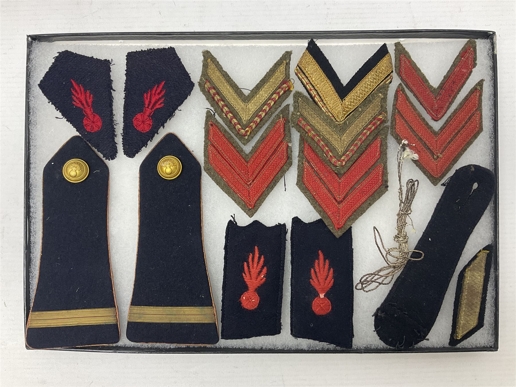 Over thirty items of French Sapeur Pompiers (Fire Service) cloth insignia and buttons c1930s/40s; in small glazed display case