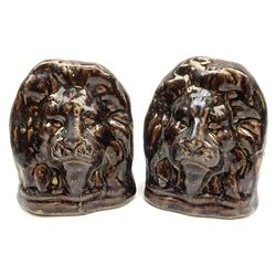 A pair of treacle glaze sash window rests, possibly Rockingham, modelled in the form of lion heads, each approximately H12.5cm.
