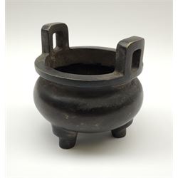 A Chinese bronze koro, of compressed bellied form with twin lug type handles, upon tripod legs, with character seal mark beneath, rim D9.5cm, including handles H10cm.
