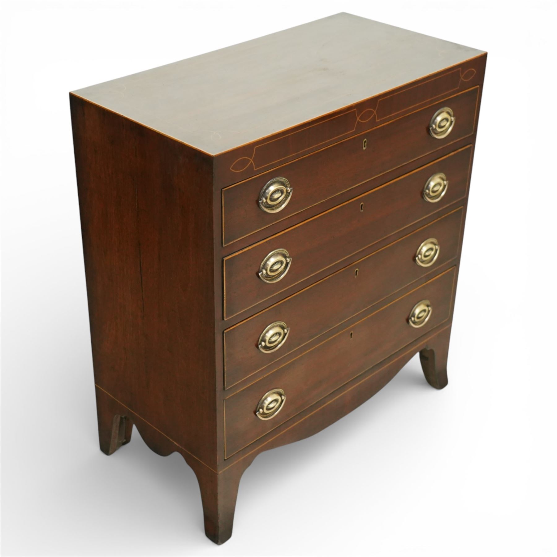 19th century Regency Revival inlaid mahogany chest, the plain rectangular top and frieze inlaid with geometric satinwood stringing, fitted with graduating long drawers fitted with pressed brass patera form handle-plates, on splayed feet with shaped apron