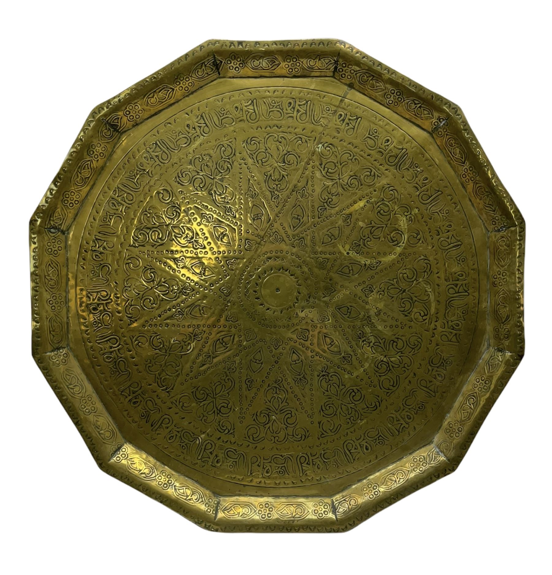 Eastern brass faceted tray with impressed script and scrolling decoration D48cm. 