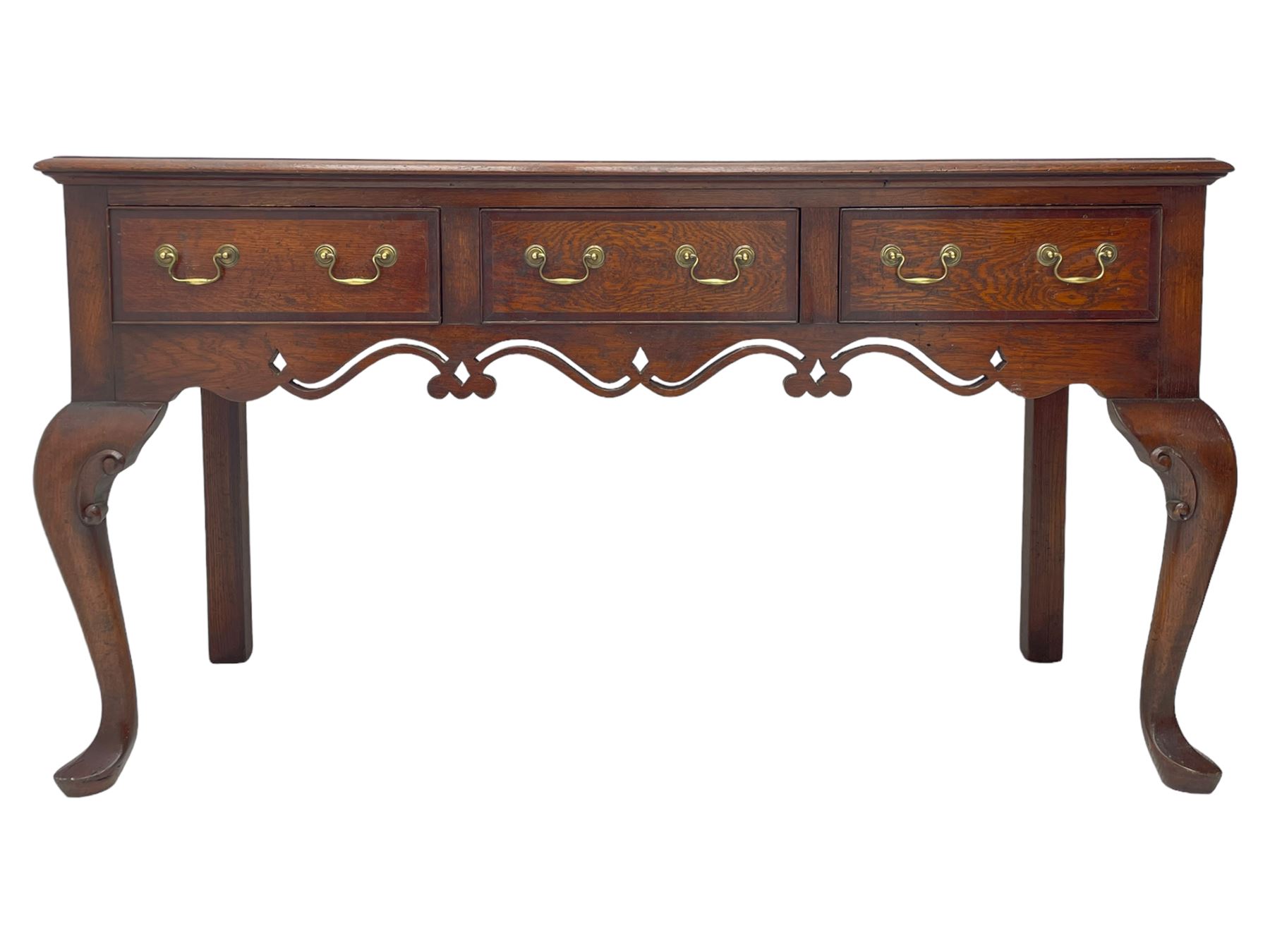 Georgian design oak and mahogany dresser base, the rectangular moulded top with mahogany band, three cocked-beaded and banded drawers over shaped a pierced apron, circular brass handle plates and swan neck handles, on C-scroll carved cabriole supports 