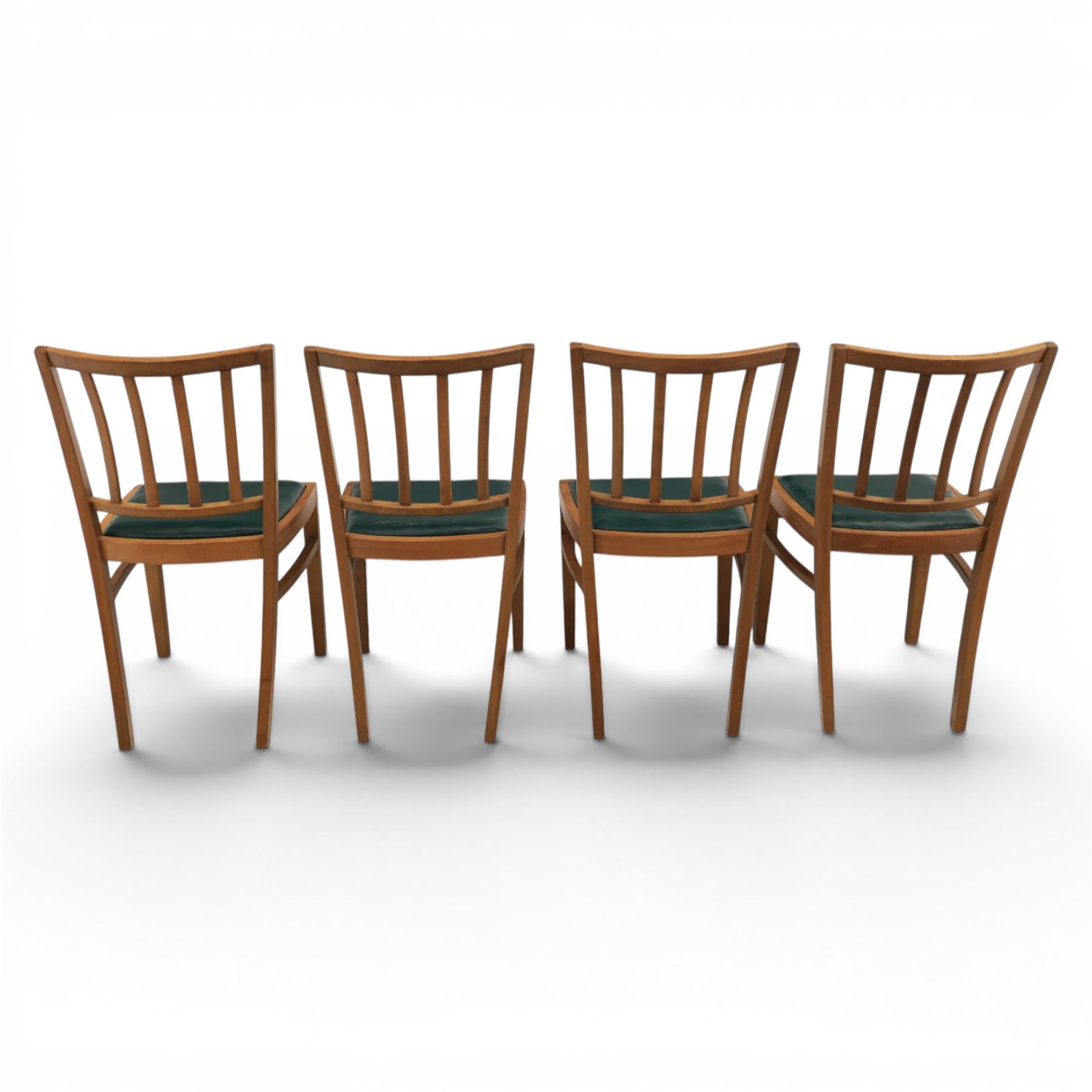 Mid 20th century teak extending dining table, together with eight teak chairs with green leather seats, extends to 154cm