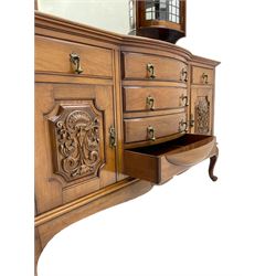 Late Victorian walnut mirror back sideboard or dresser, the raised back fitted with two curved and lead glazed cabinets, central arched bevelled mirror, the sideboard with break bowfront, fitted with six drawers and two cupboards, the cupboard doors panelled and carved with scrolls, shell and plant motifs, shaped apron with cabriole feet
