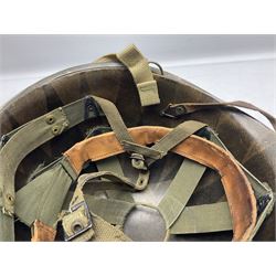 American first type paratrooper helmet with post-WW2 strap and D-rings and later 1944 liner bearing Firestone Tyre and Rubber Company mark; green textured finish