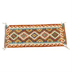 Two Chobi flatweave kilim runners with a repeating stepped diamond medallion design in live green, rust, teal, purple, and ivory, framed by chevron and geometric borders, (2)