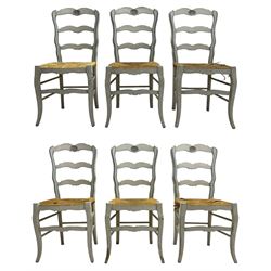 20th century set of six painted hardwood French design dining chairs, shaped ladder back, the cresting rail carved with shell motifs, rush seat on cabriole front supports united by turned stretchers, in distressed grey and blue paint finish 