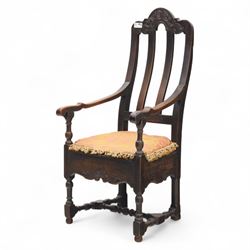18th century oak provincial armchair, arched and carved cresting rail above triple splat back, shaped arms on turned supports, stuff-over seat upholstered in damask fabric, carved front frieze on turned legs united by stretchers