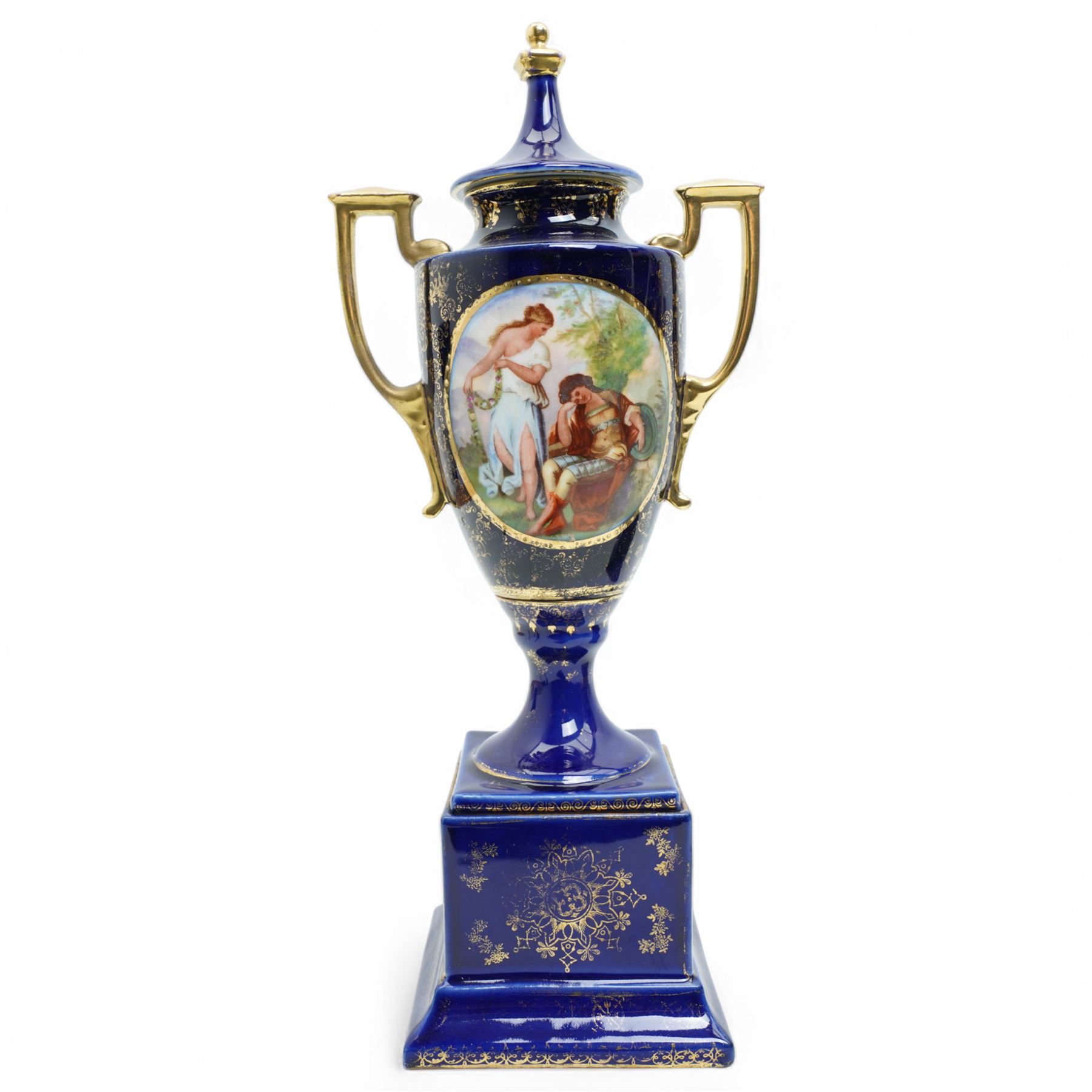 Pair of Vienna style blue porcelain two handled vases and covers painted with classical scenes on a dark blue and gilt ground and square socles, blue beehive mark H35cm