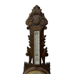 A 1920s oak cased patented aneroid barometer with openwork decorative carving, 8” enamel dial recording air pressure from 26 to 32 inches with weather predictions in gothic script, steel indicating hand and brass recording hand within a brass bezel and flat glass (glass cracked), with a boxed mercury thermometer recording the temperature in degrees centigrade and Fahrenheit.    

