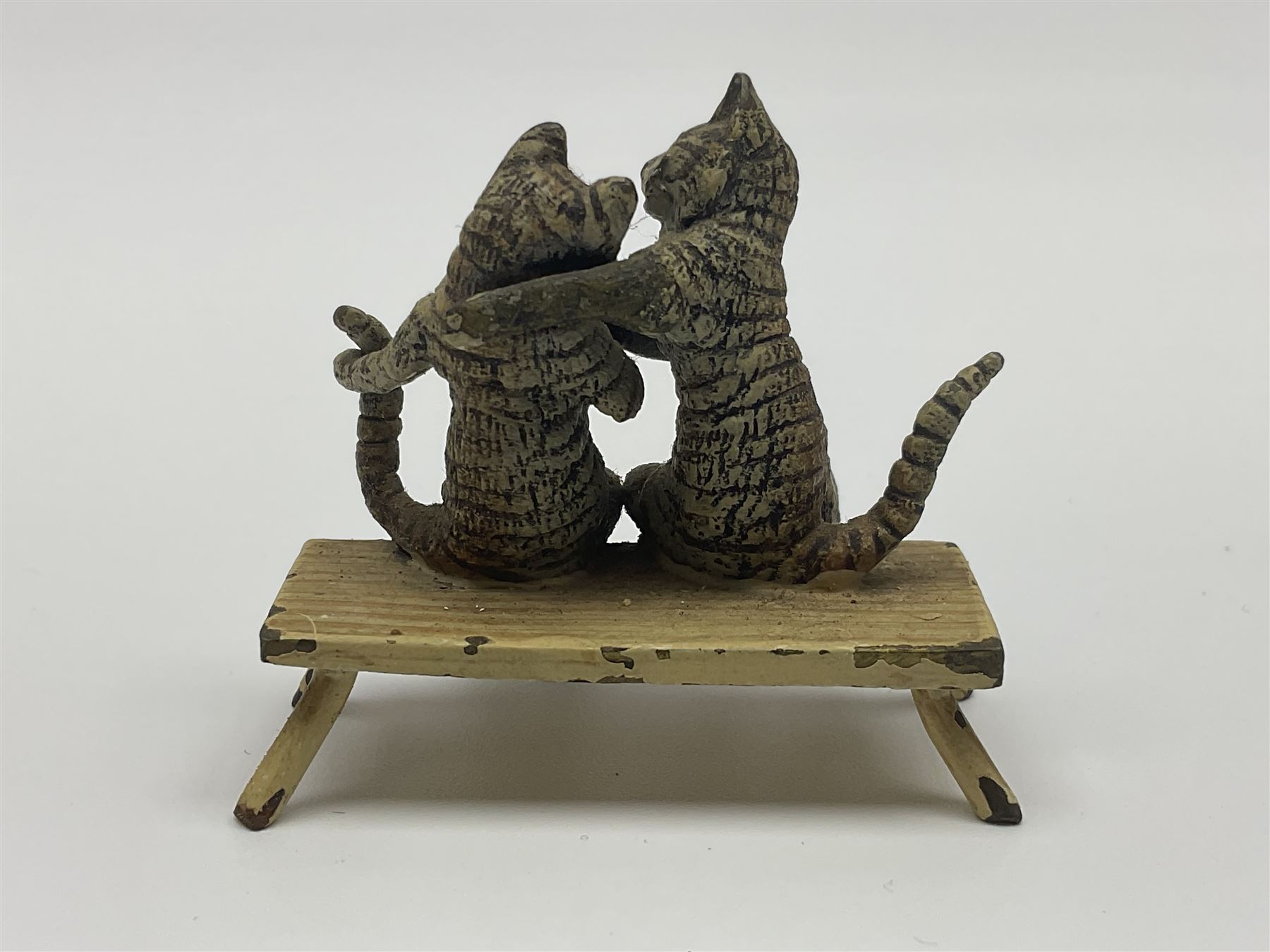 After Bergmann, two cold painted bronze figures, the first modelled as two cats on a bench hugging, the second a cat caning a kitten