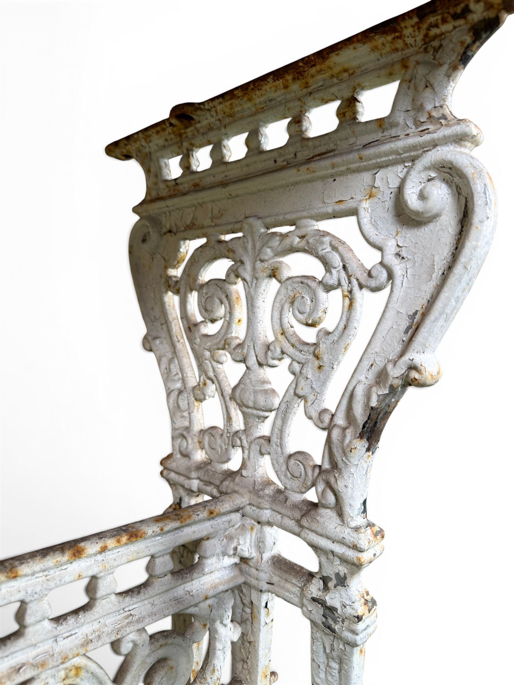Victorian cast iron garden table, rectangular slate top raised on pierced scrolling foliate end supports with urn and column designs, united by a spindle support stretcher with scrolling acanthus spandrels, stamped 'Registered Design' with indistinct number, in distressed white painted finish