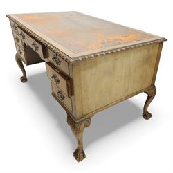 Waring & Gillow - Early 20th century mahogany desk, the leather-inset top above a shaped kneehole, central compartmented frieze drawer flanked by twin banks of of three drawers, each with brass handles, raised on cabriole legs with carved ball and claw feet (Height from floor to underside 62cm)