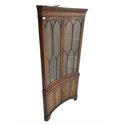 Bevan Funnell Reprodux - mahogany concave corner display cabinet, the moulded and dentil cornice over two astragal glazed doors, double cupboard below enclosed by figured doors, on bracket feet