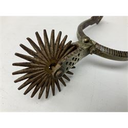 Pair of late 19th century South American iron spurs, engraved silver mounts, with sunburst rowls