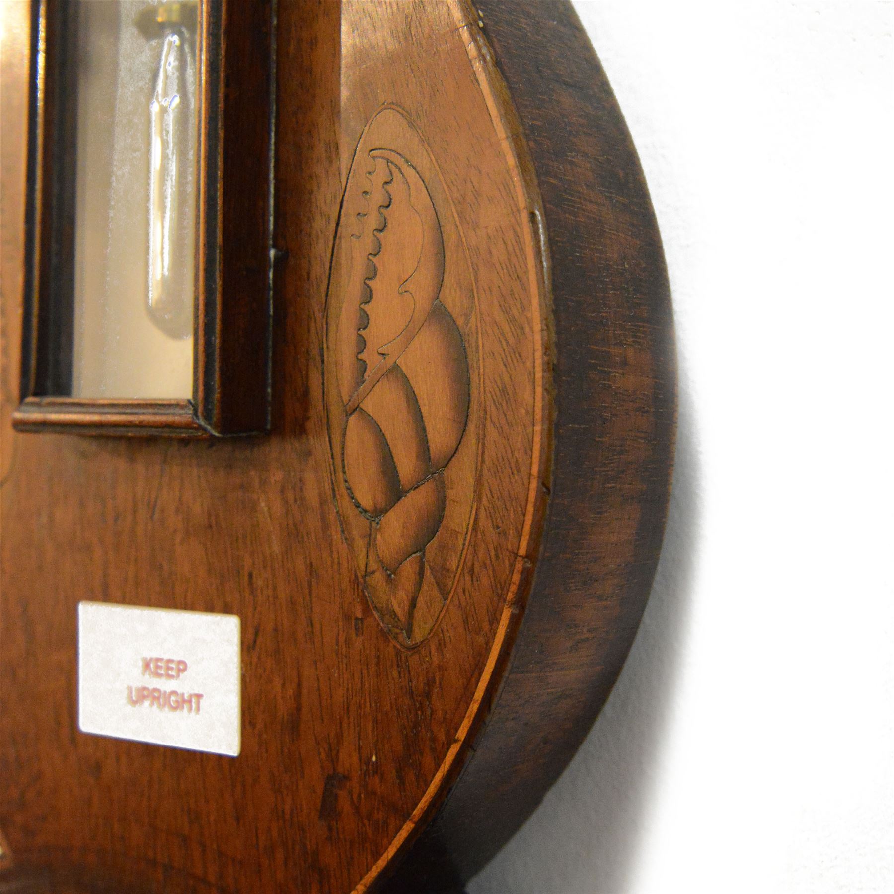 Early 19th century-Sheraton two instrument mercury barometer c1820, with a break arch top and round base, mahogany veneer with inlaid motifs and stringing to the edge, surface mounted mercury thermometer recording degrees Fahrenheit and an 8” silvered register with predictions and recording barometric air pressure from 28 to 31 inches, with a steel indicating hand and brass recording hand. Dial inscribed P. Nicho. 
Mercury present, syphon tube and pulleys intact.