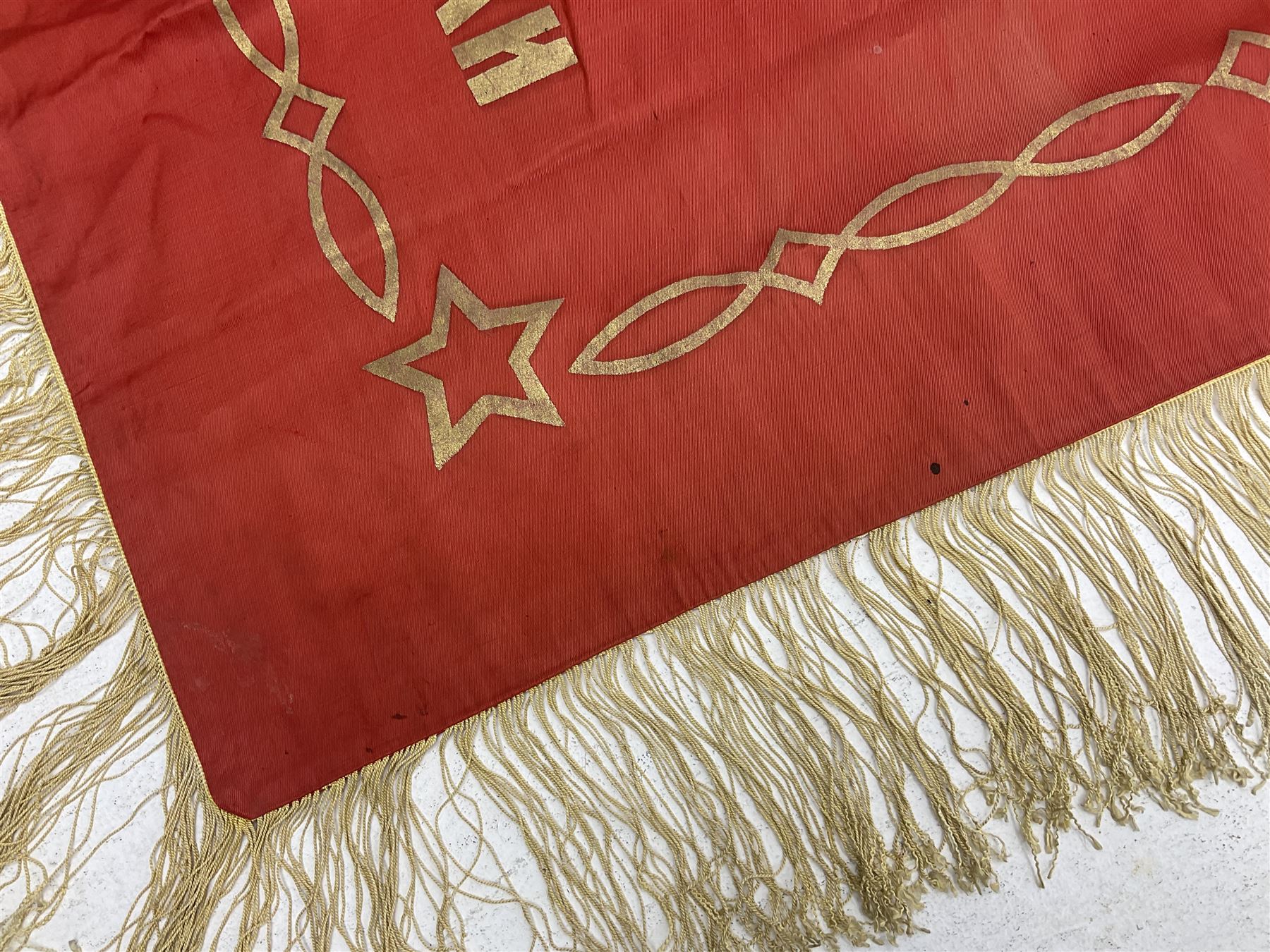 1970s Soviet banner printed in gold on a red ground, roughly translates as 'Transferable Banner - To the winner in the Socialist Competition' and 'Work Study Live by Communism' verso; wreath of wheat ears to either side; tassels on three sides 110 x 155cm