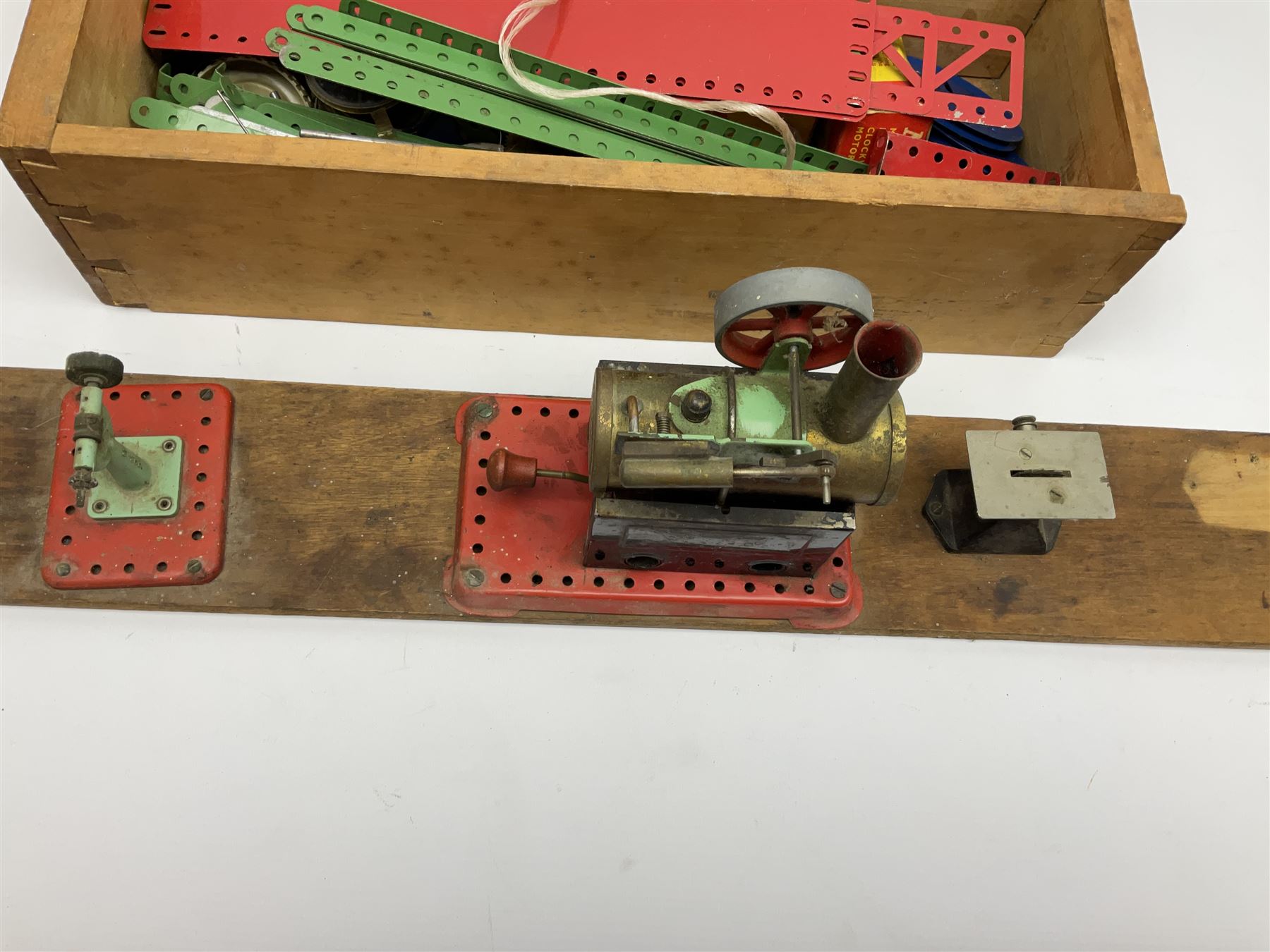 Mamod small stationary steam plant with circular saw bench and grinder mounted on long wooden board L107cm; and quantity of predominantly red/green Meccano in wooden box with die-cast models etc
