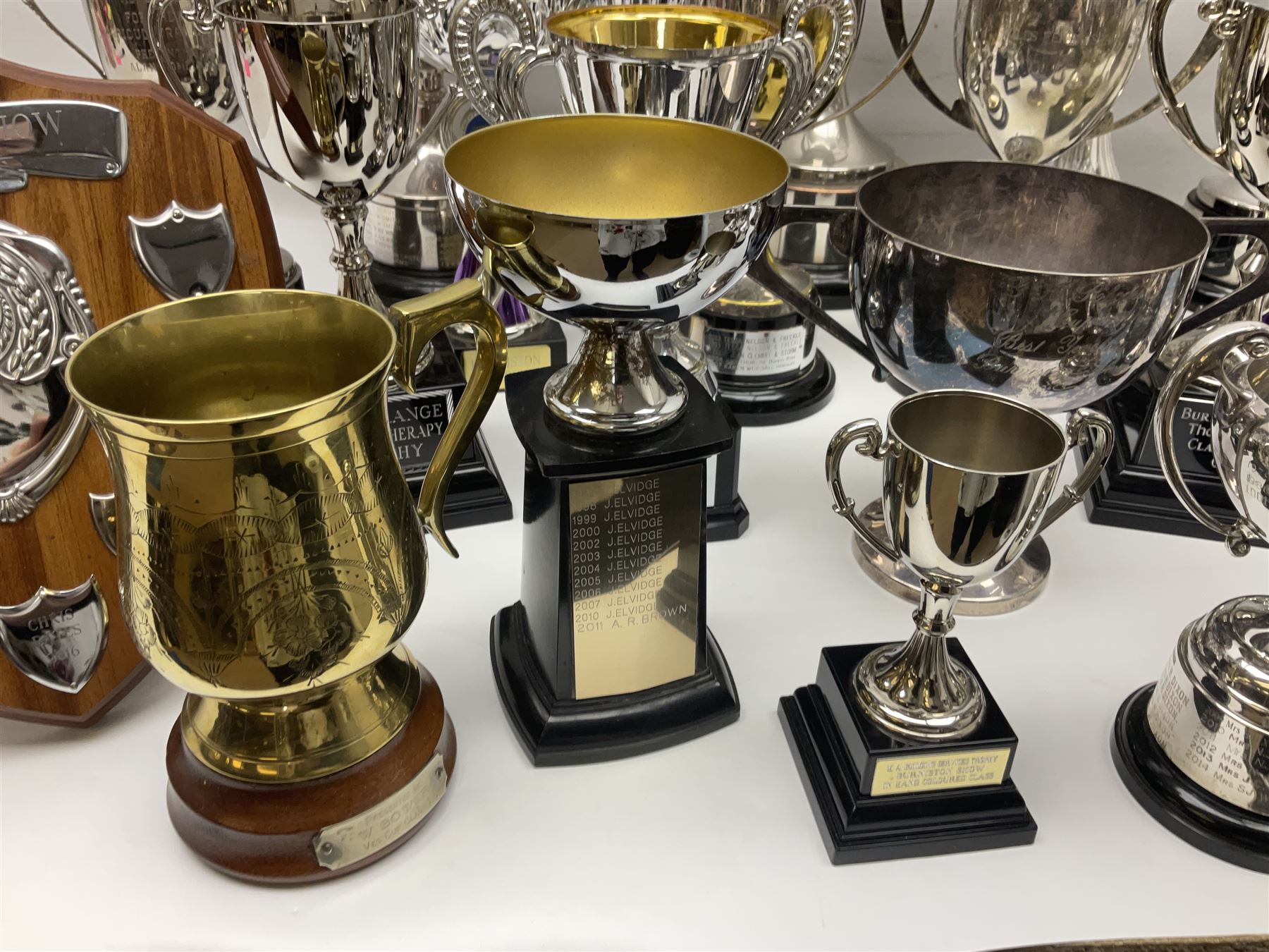 Collection of silver plated and metal trophy cups and winners plaques, all relating to the Burniston and District Show, most engraved with competitions and winner's names, in three boxes 