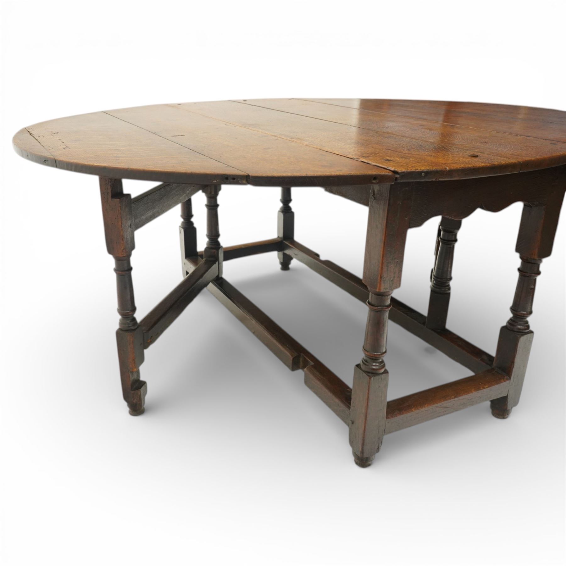 18th century large oak gateleg table, of plank top construction with visible dowels, with drop leaves to form an oval table 167cm in width, raised on block and turned supports
