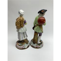 Pair of 19th Century continental figures, possibly German, the first example modelled as a man carrying cooking equipment seated upon a tree stump, the second modelled as a woman in a bonnet carrying shoes. H28cm.  