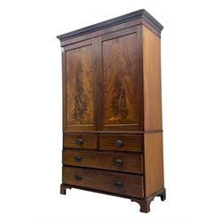 Early 19th century mahogany linen press cupboard, projecting moulded cornice over figured frieze, two panelled doors enclosing shelves, fitted with two short and two long cock-beaded drawers, on bracket feet 